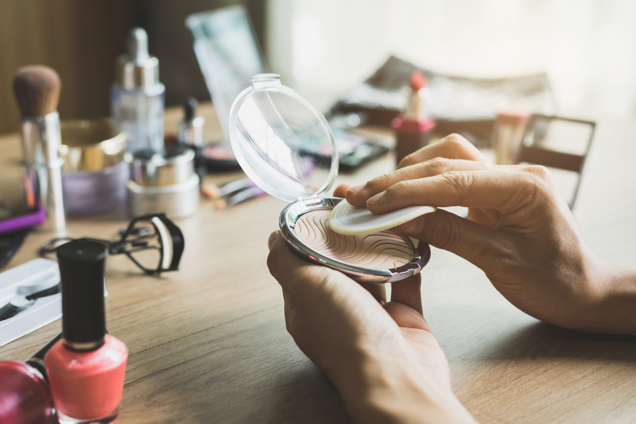 Girl doing makeup on dressing table with cosmetics